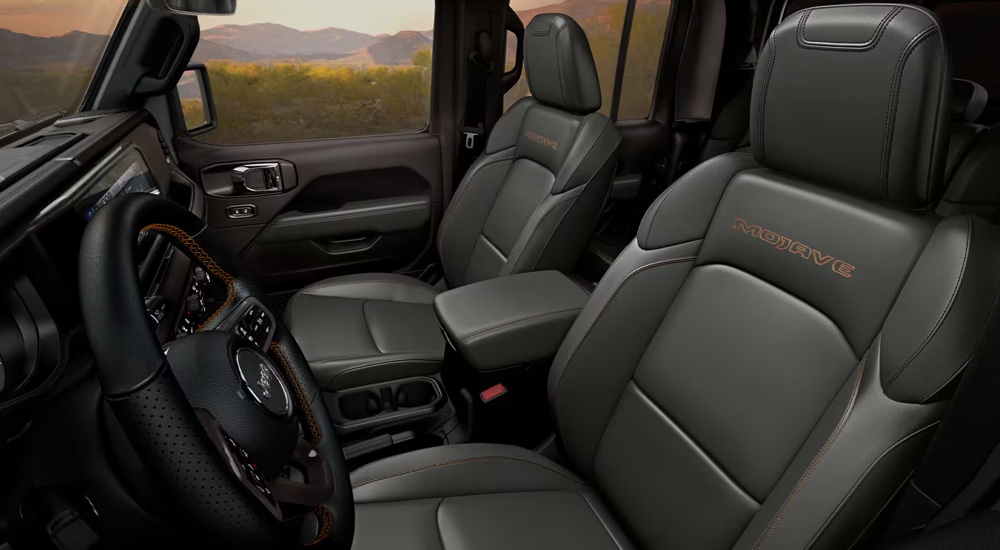 The front seats inside a 2024 Jeep Gladiator Mojave for sale.