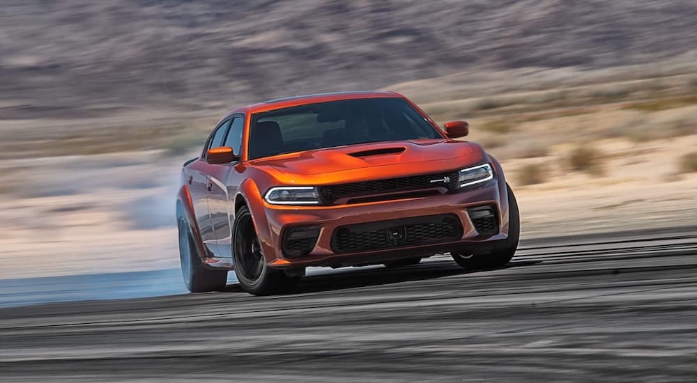An orange 2023 Dodge Charger Scat Pack Widebody is shown from the front at an angle.