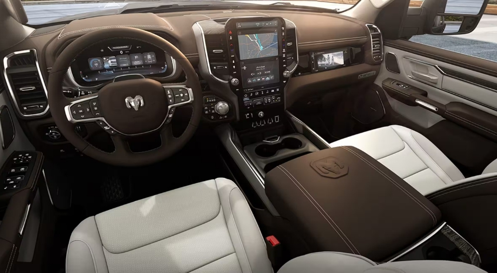 The brown and tan leather cabin of a 2025 Ram 1500 Laramie at a Ram dealer.