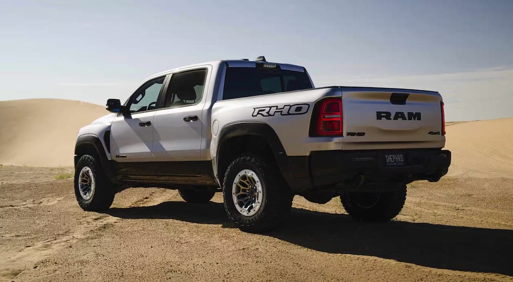 A silver 2025 Ram 1500 RHO is parked in a desert.