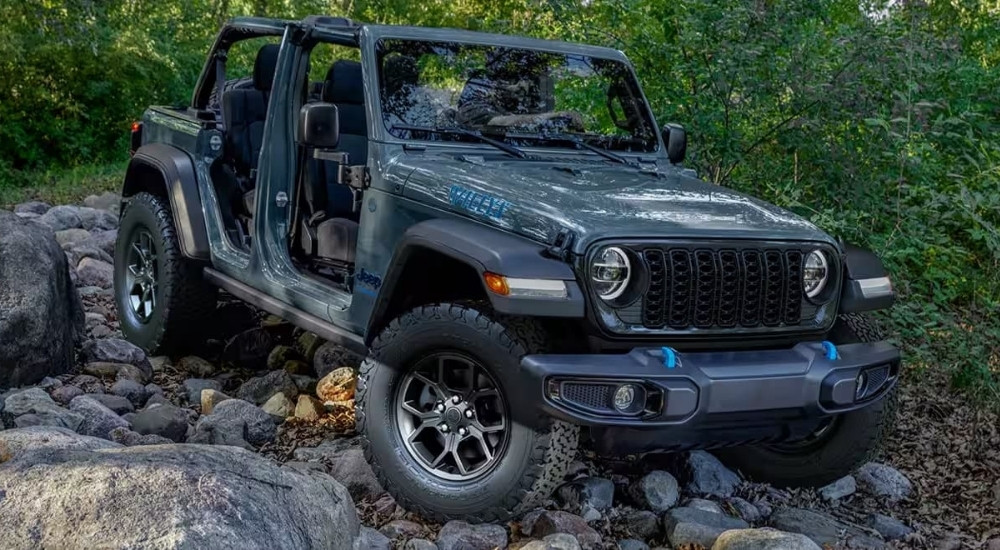 A grey 2025 Jeep Wrangler 4xe Willy's parked on rocks.