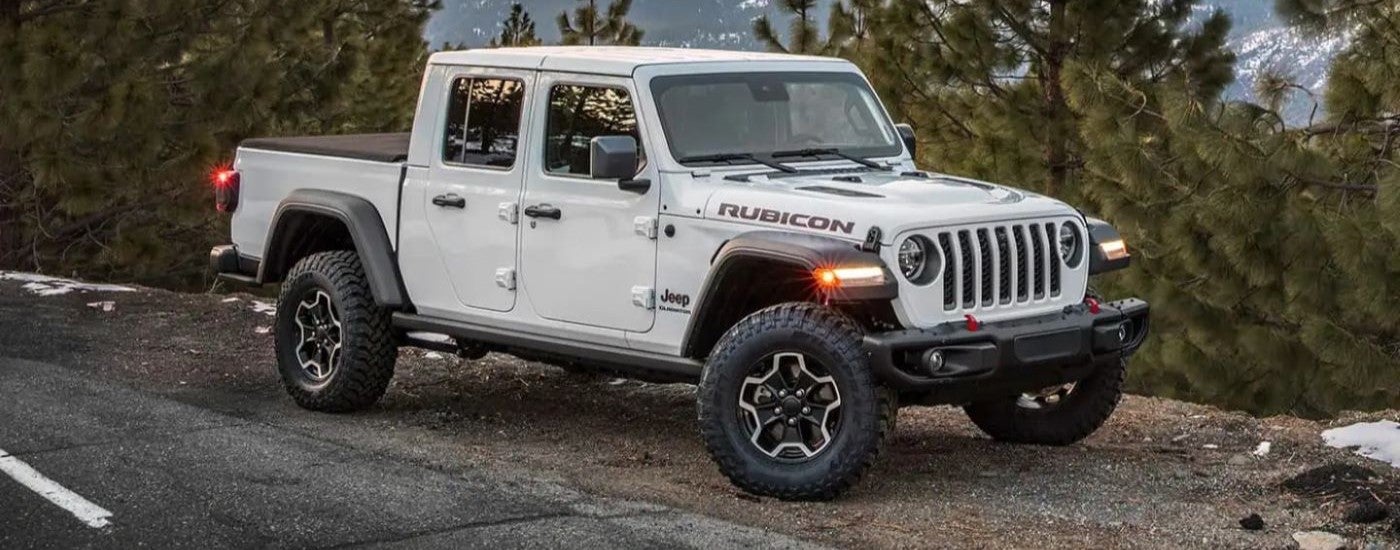 A white 2024 Jeep Gladiator Rubicon parked off-road.