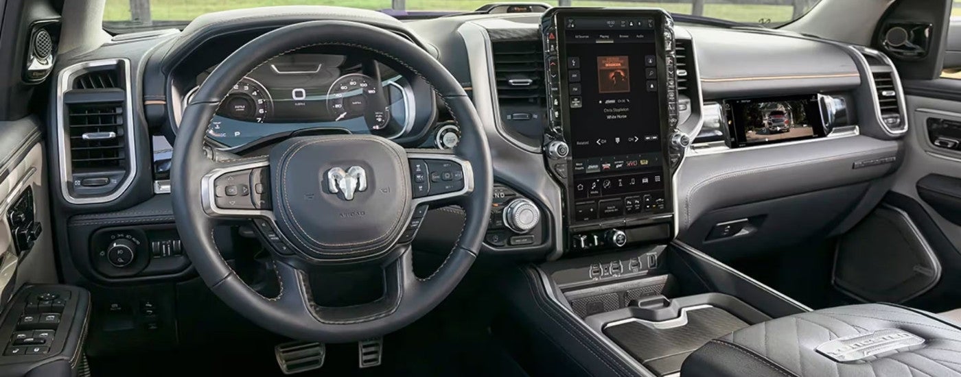The black interior of a 2025 Ram 1500 Tungsten is shown from the driver's seat.