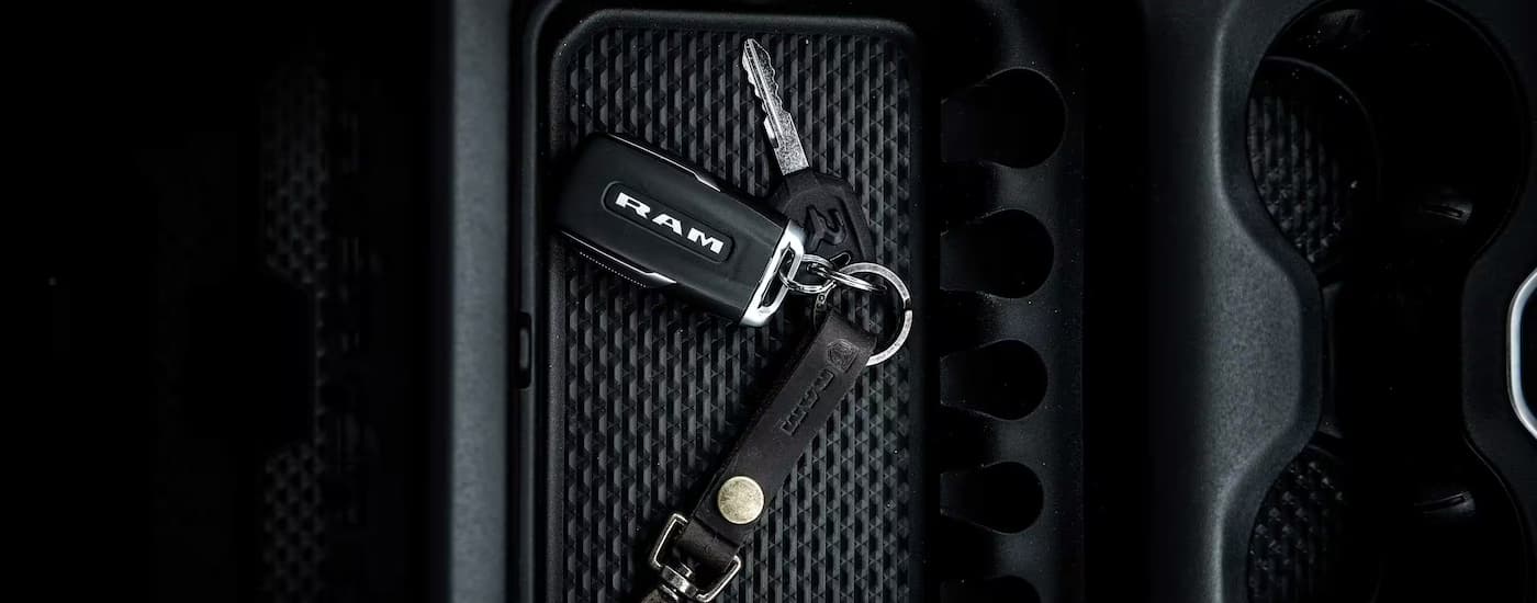 A close up of a set of car keys in the center console of a 2024 Ram 1500 at a Ram dealer near Greensboro.