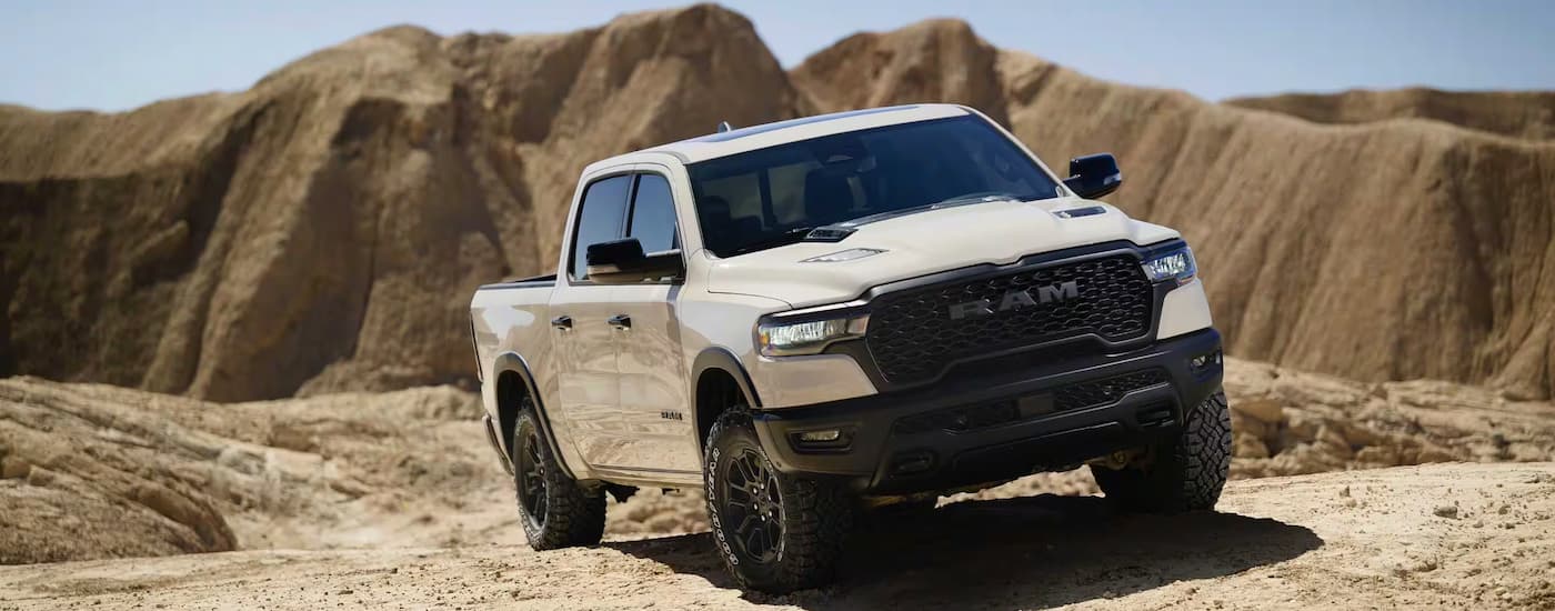 A white 2025 Ram 1500 Rebel driving off-road on a desert.